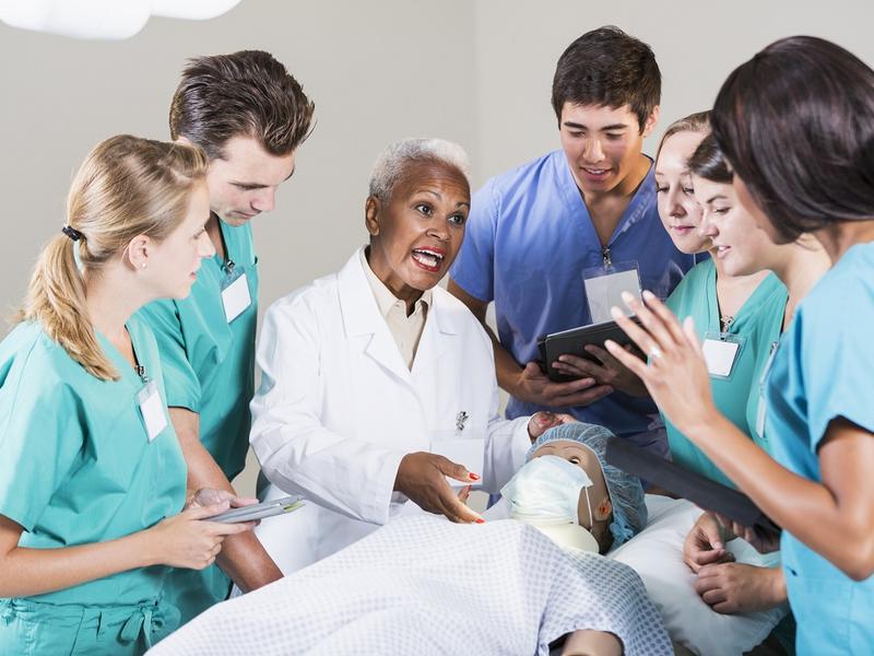 Group of residents gathered around a physician