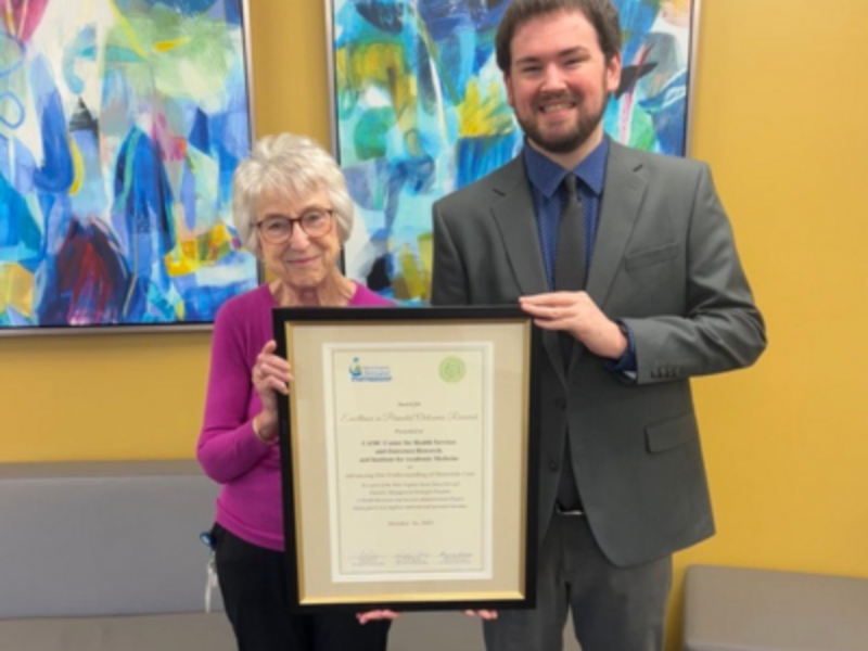 Mary Emmett, PhD, and Chance Pettry holding the certificate for the Award for Excellence in Perinatal Outcomes Research