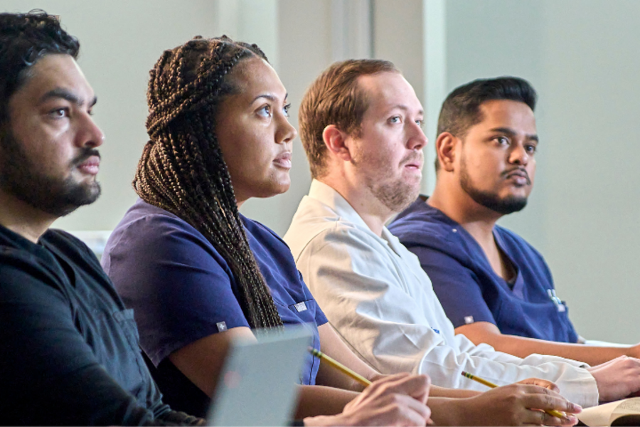 Residents and fellows candid, sitting at table