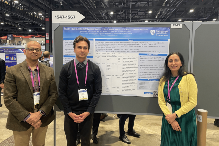Fellows and faculty standing with research poster