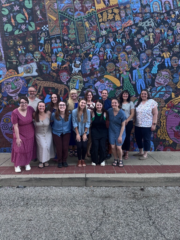 Group photo of the CAMC Psychology program participants in front of art display.