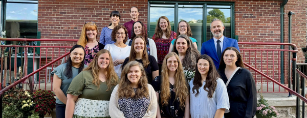 Group photo of interns and faculty outside restaurant