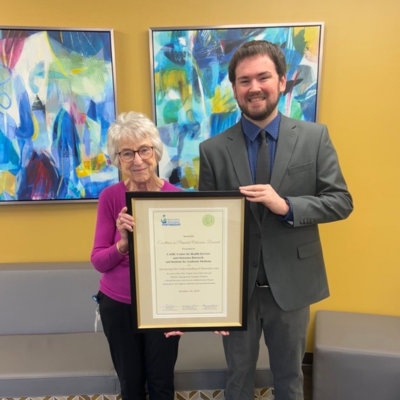 Mary Emmett, PhD, and Chance Pettry holding the certificate for the Award for Excellence in Perinatal Outcomes Research