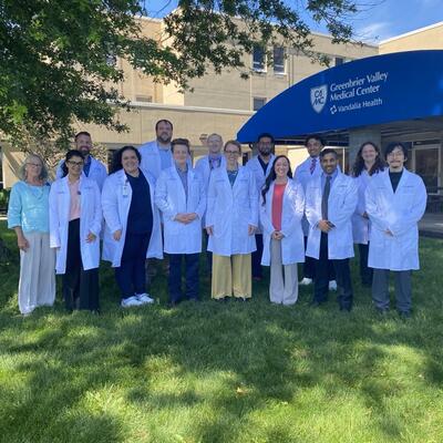 Group photo of residents, staff and faculty outside building